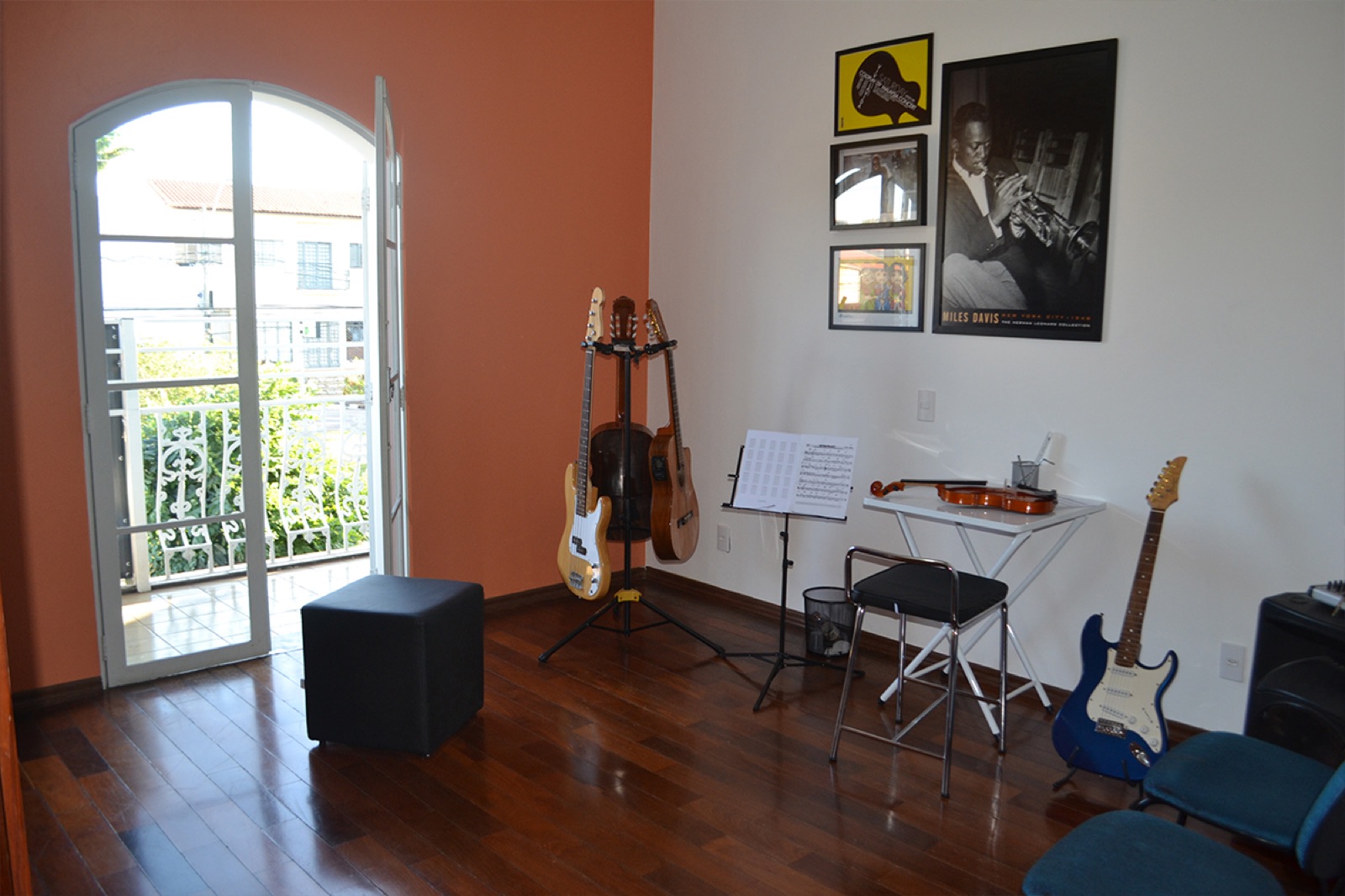 Sala de aula com violão, guitarra e estante de partitura
